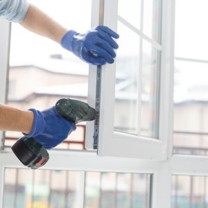 Handyman,Adjusting,White,Pvc,Plastic,Window,Indoors.,Worker,Using,Screwdriver